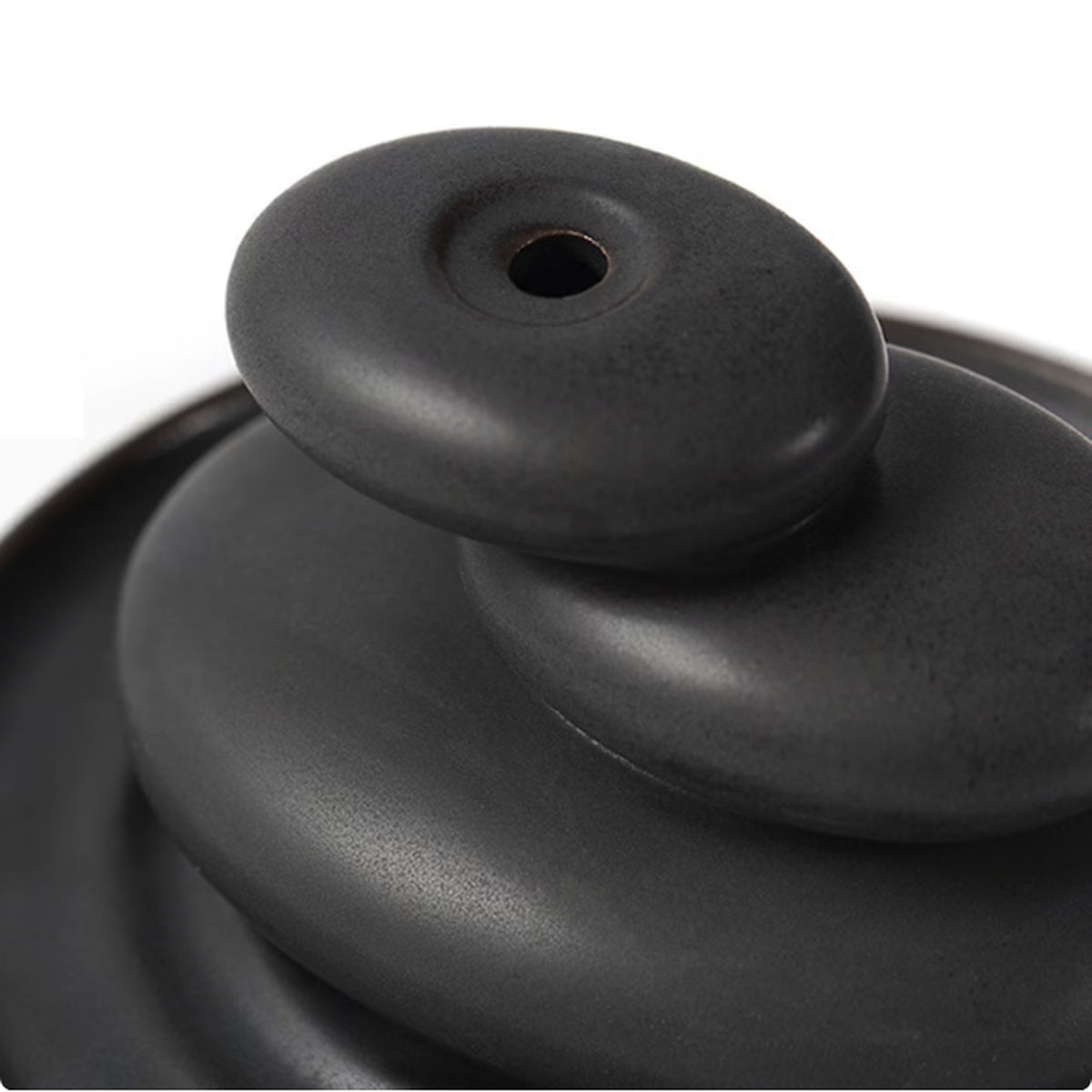 Close-up of black ceramic backflow incense burner with top cone opening