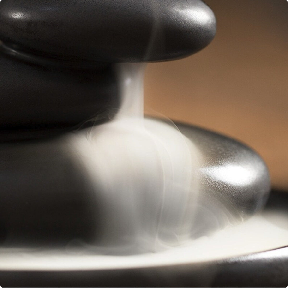 Waterfall smoke flowing through stacked stone ceramic incense burner