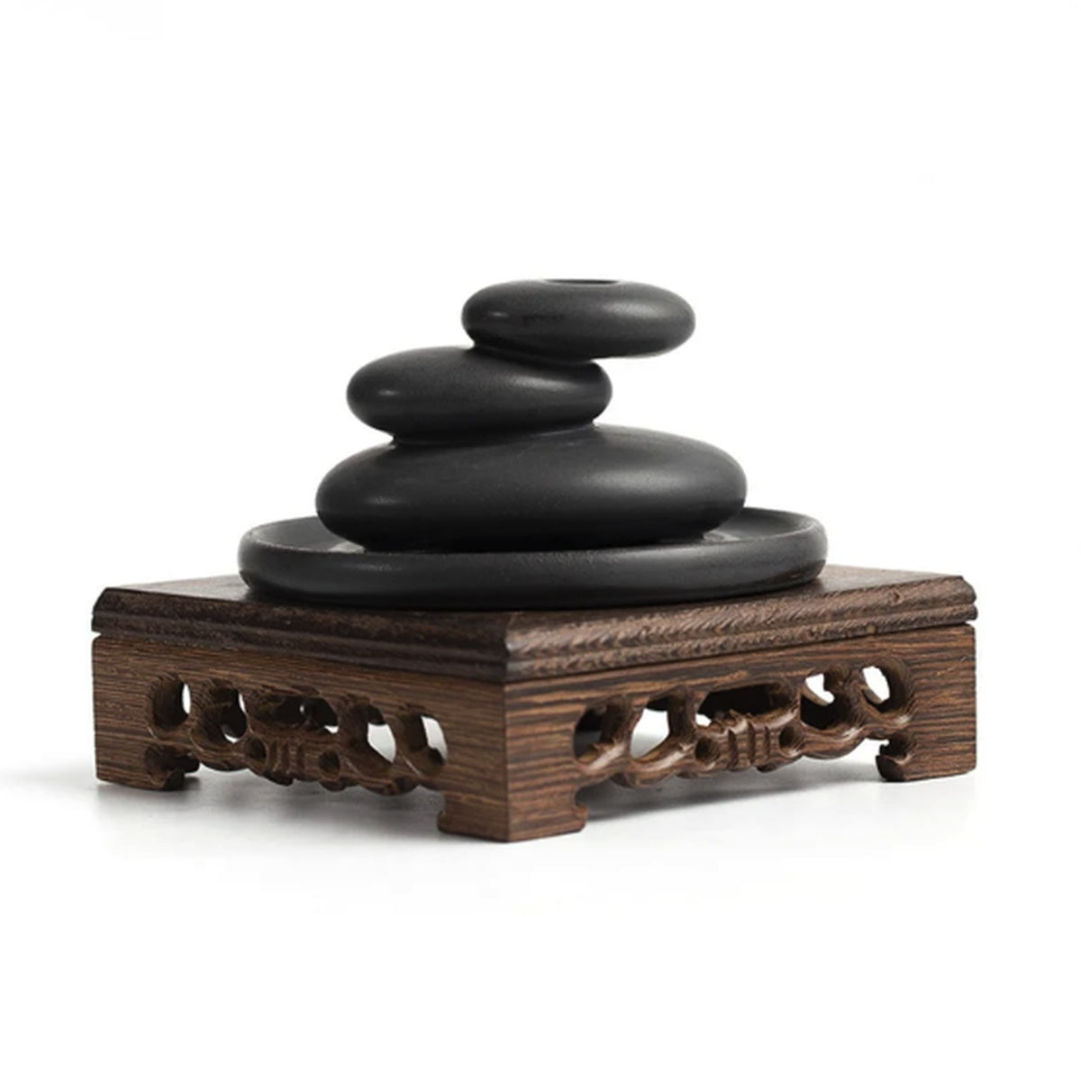 Black ceramic stacked stone backflow incense burner displayed on wooden stand