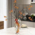 Stained glass twisted swirl vase with amber and teal accents on table