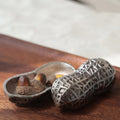 Stainless steel peanut shell trinket box open on wooden tray