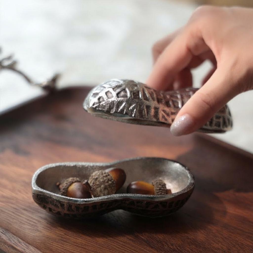 Hand lifting the lid of the silver peanut trinket box