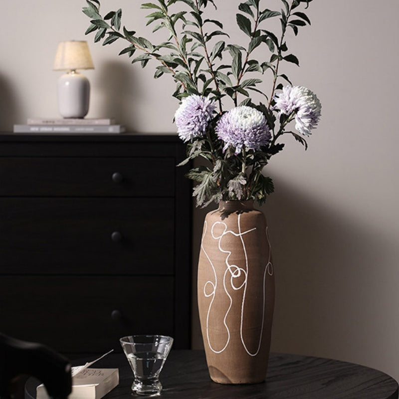 Close up of brown stoneware vase with white abstract lines