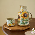 Front view of stoneware pitcher and cup set with sunflower design