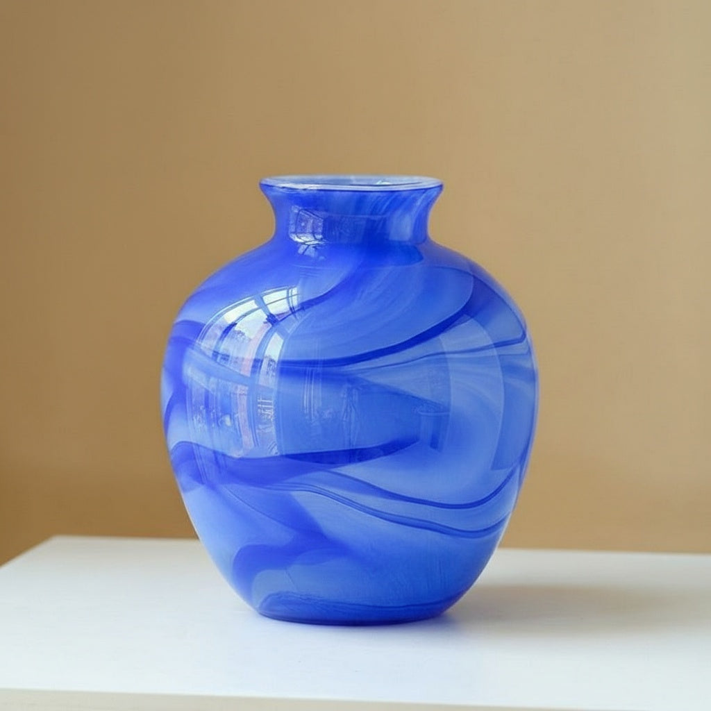 Detail of bulbous blue glass vase with white swirls