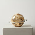Large brown swirled glass planet sculpture with clear ring