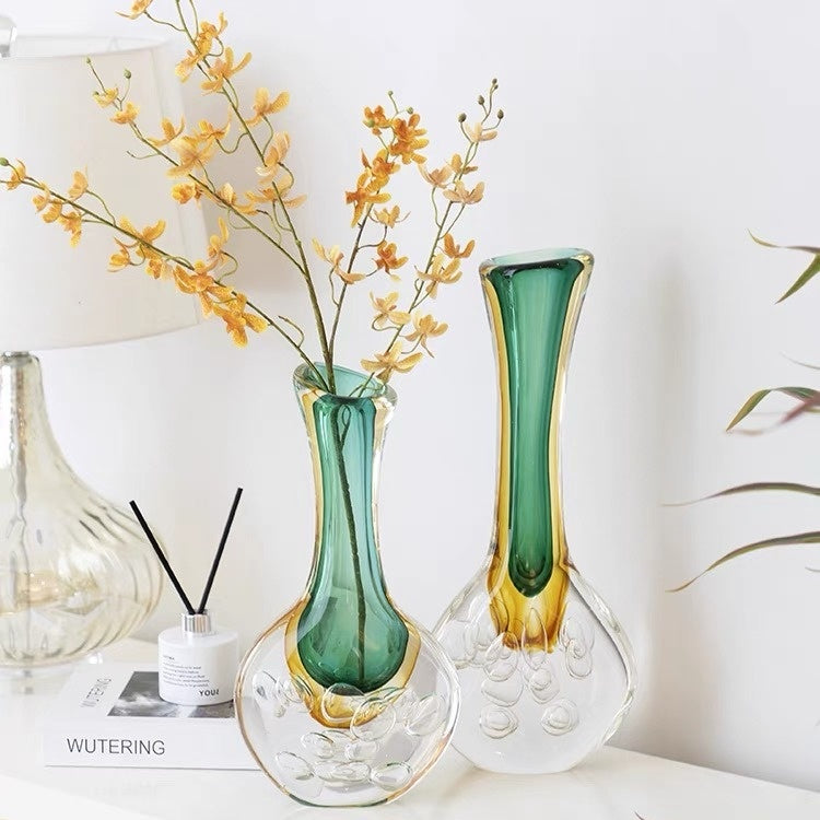 Two art glass vases with flowers on white table