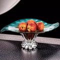 Gradient teal and amber glass bowl holding apples