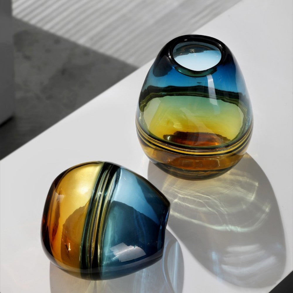 Teal and amber glass vases displayed as sculptural decorative centerpieces in natural light