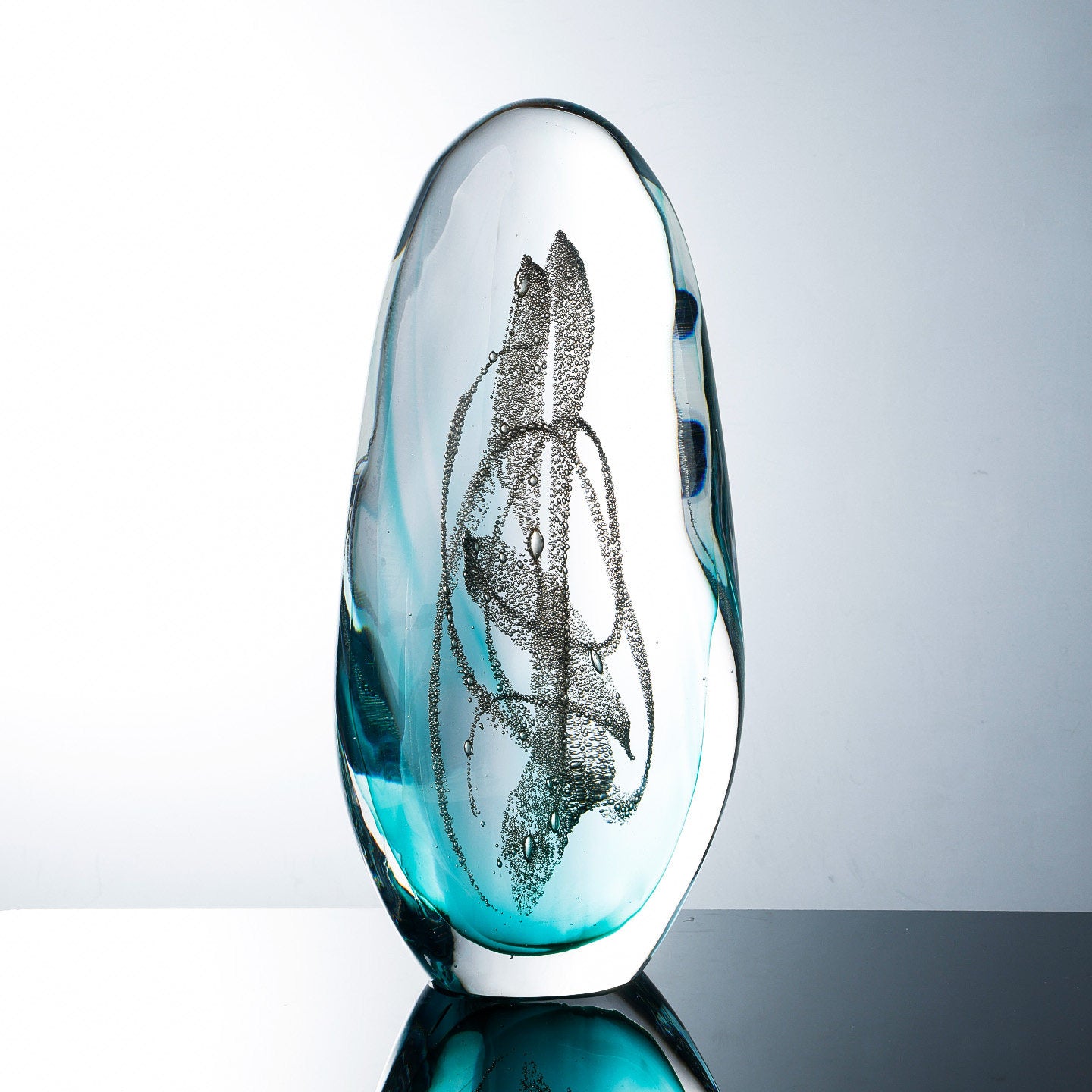 Front view of teal and clear art glass ovoid sculpture