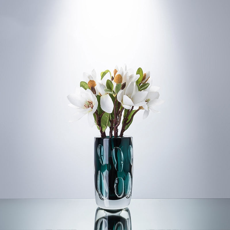 Teal glass vase styled with white magnolia flowers