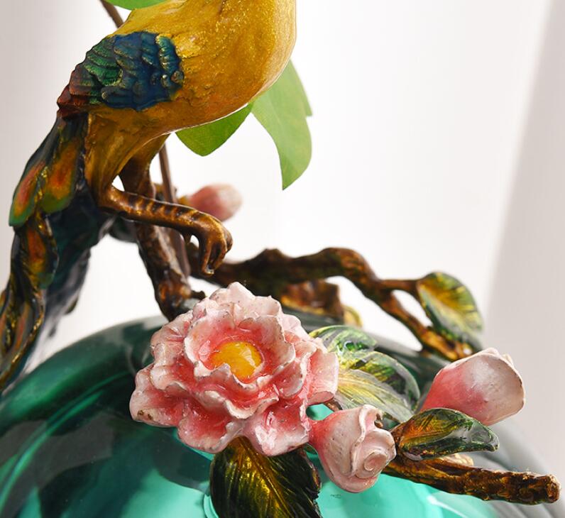 Detail of hand painted enamel peacock and flower sculpture