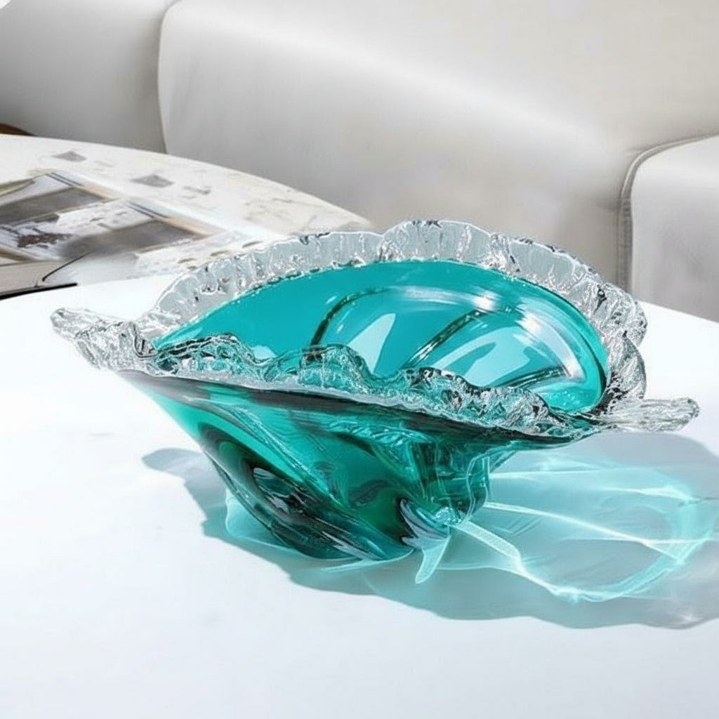 Teal art glass bowl with waved rim on white table