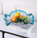 Teal art glass wavy centerpiece bowl holding fruit on table