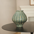 Front view of teal and beige ribbed ceramic vase on table