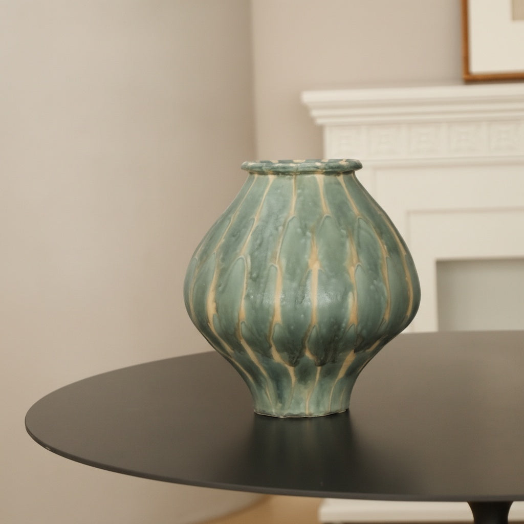 Front view of teal and beige ribbed ceramic vase on table