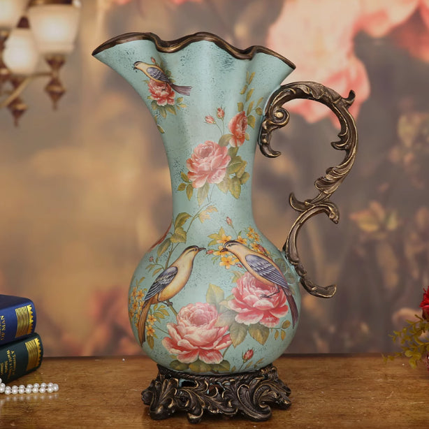 Front view of teal ceramic pitcher vase with floral and bird motifs