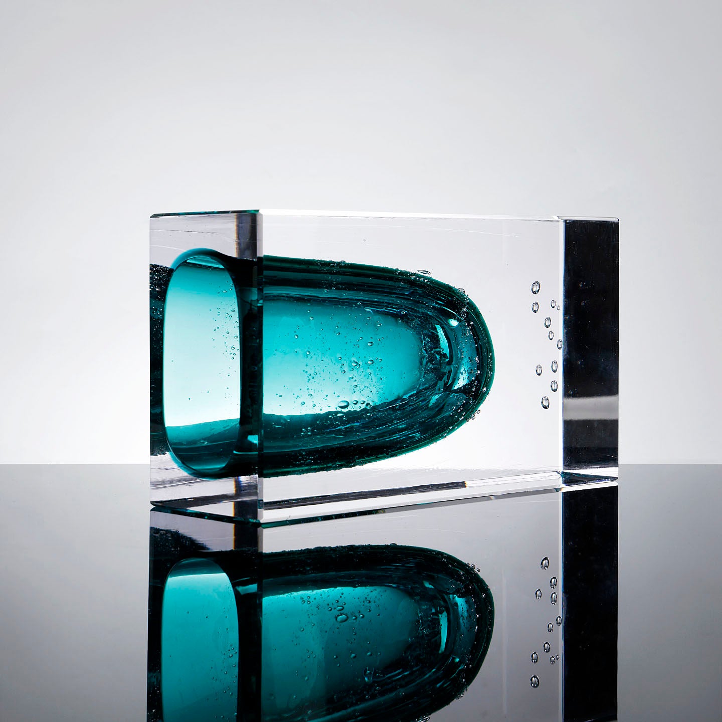 Horizontal view of glass vase reflecting on surface