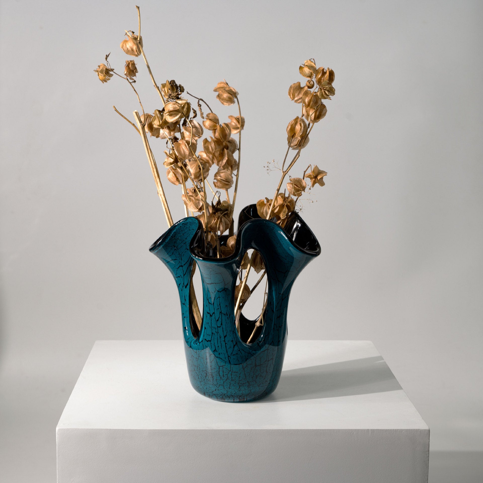 Abstract teal glass vase with dried botanicals