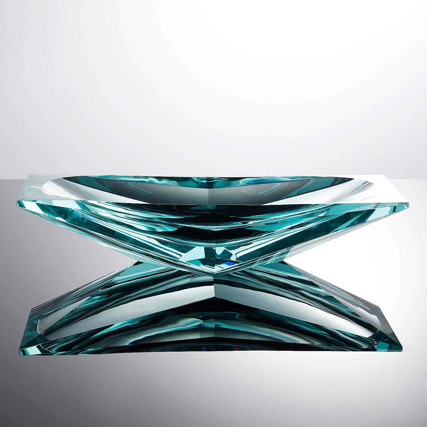 Front view of sculptural teal glass centerpiece