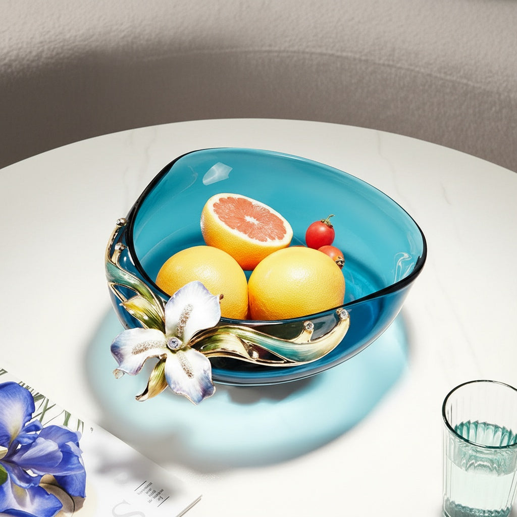 Teal glass fruit bowl with enamel flower accent filled with fruit