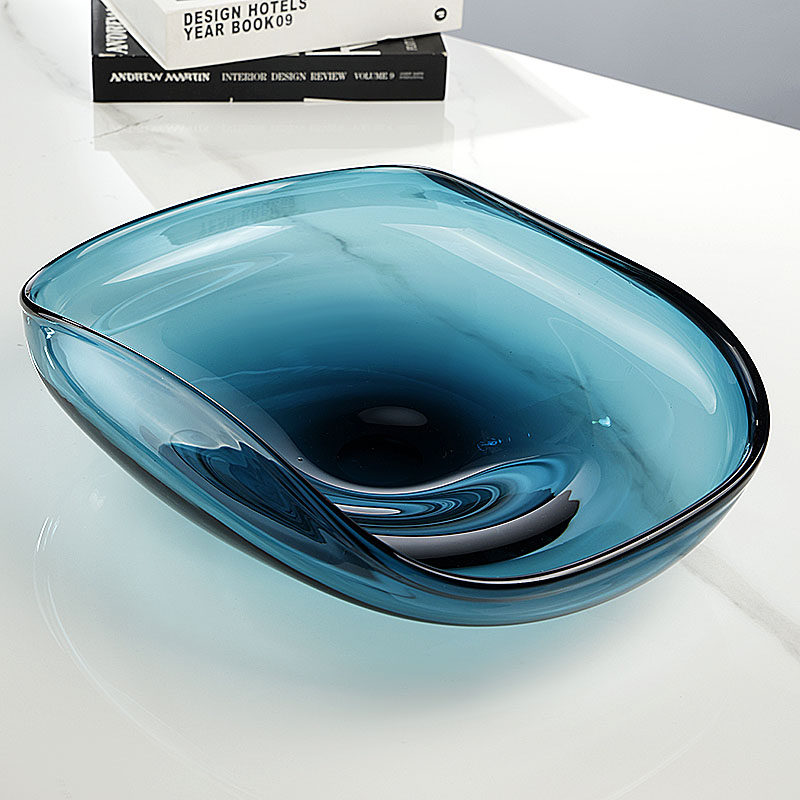 Empty teal glass bowl showing organic wavy rim