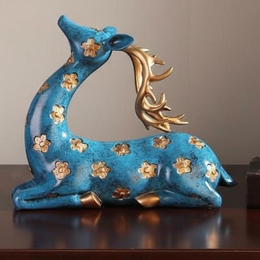 Side view of sitting teal and gold floral deer statue