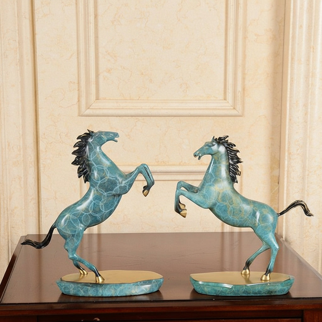 Two teal and gold patina horse sculptures facing each other