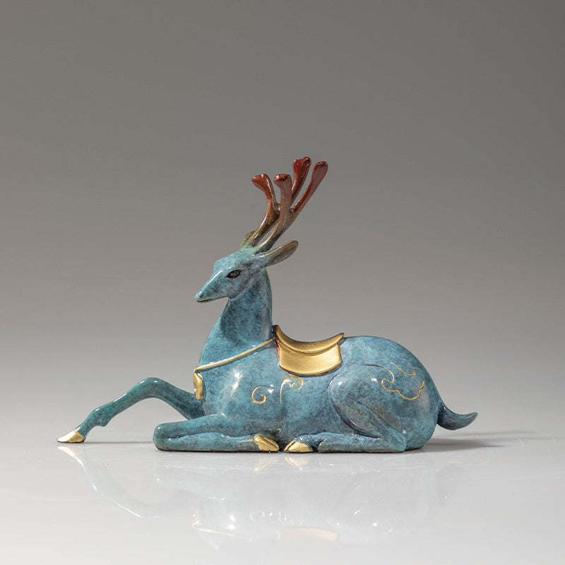 Side view of teal brass deer figurine with gold saddle