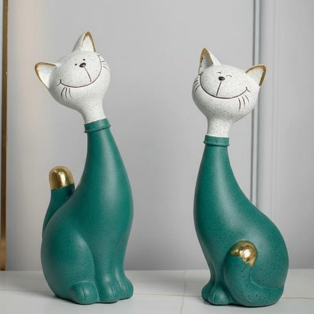 Front view of teal resin cat sculptures with gold accents