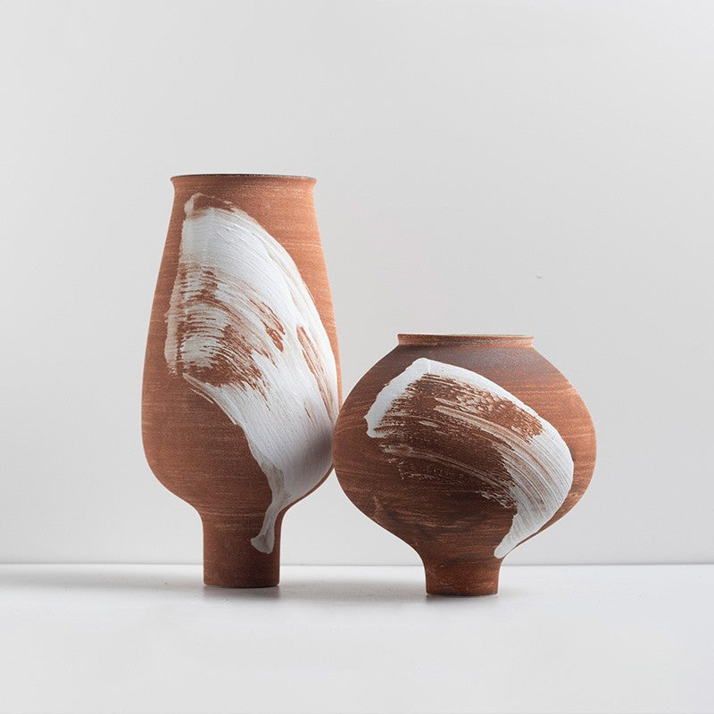 Front view of large and medium terracotta vases with abstract white art