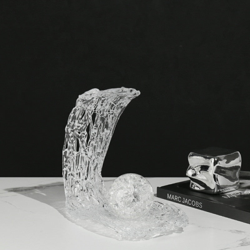 Angled view of clear acrylic abstract sculpture on book