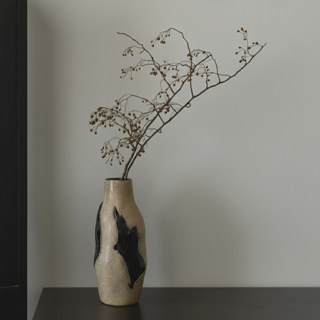 Textured beige and black organic glass vase with dried branches