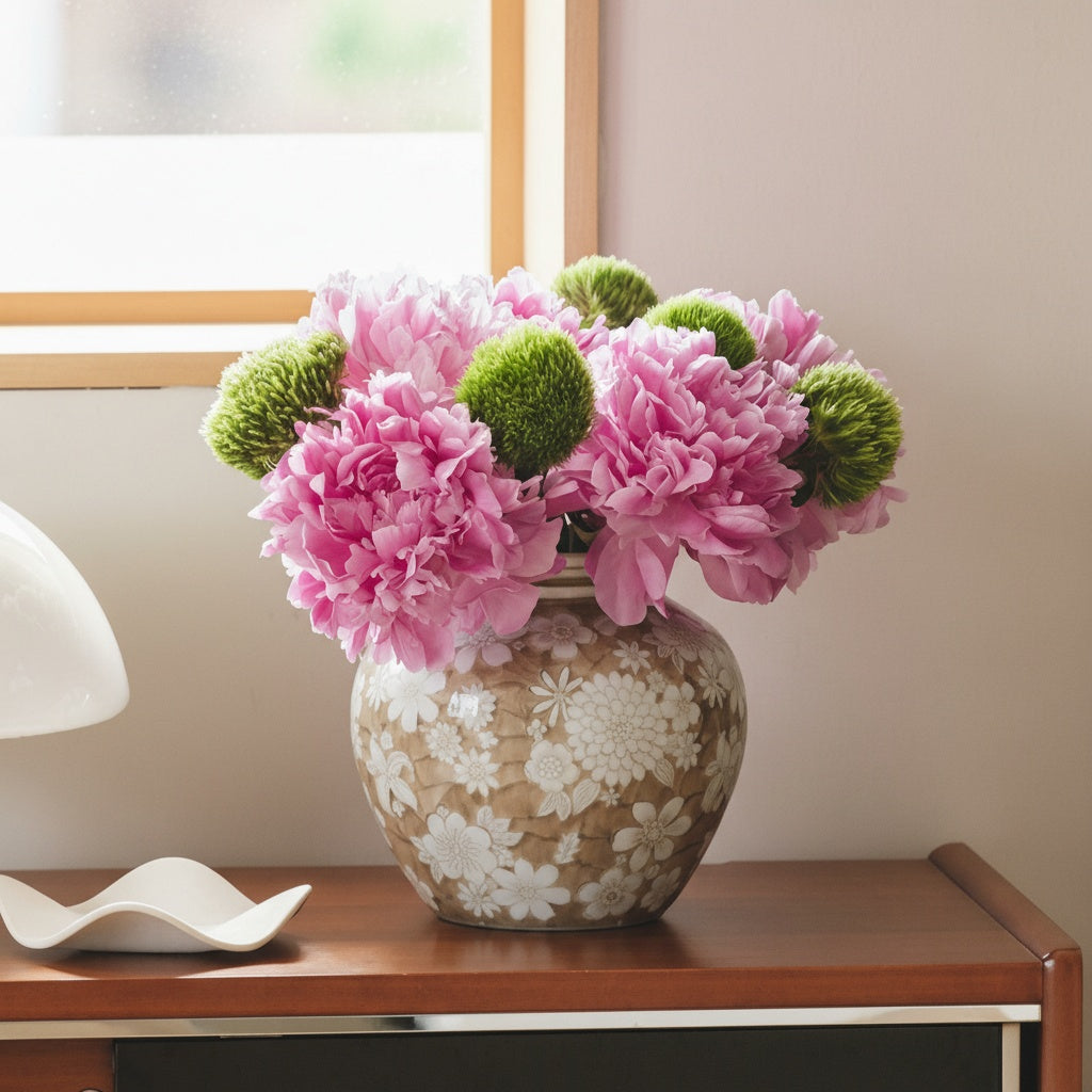 Beige and white floral ceramic vase with pink peonies on sideboard