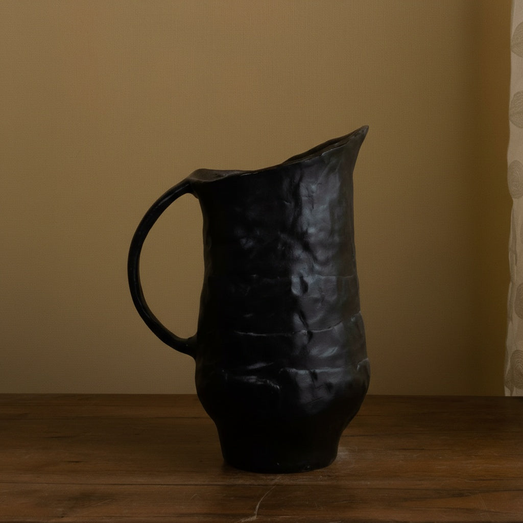 Side view of textured black ceramic pitcher with handle