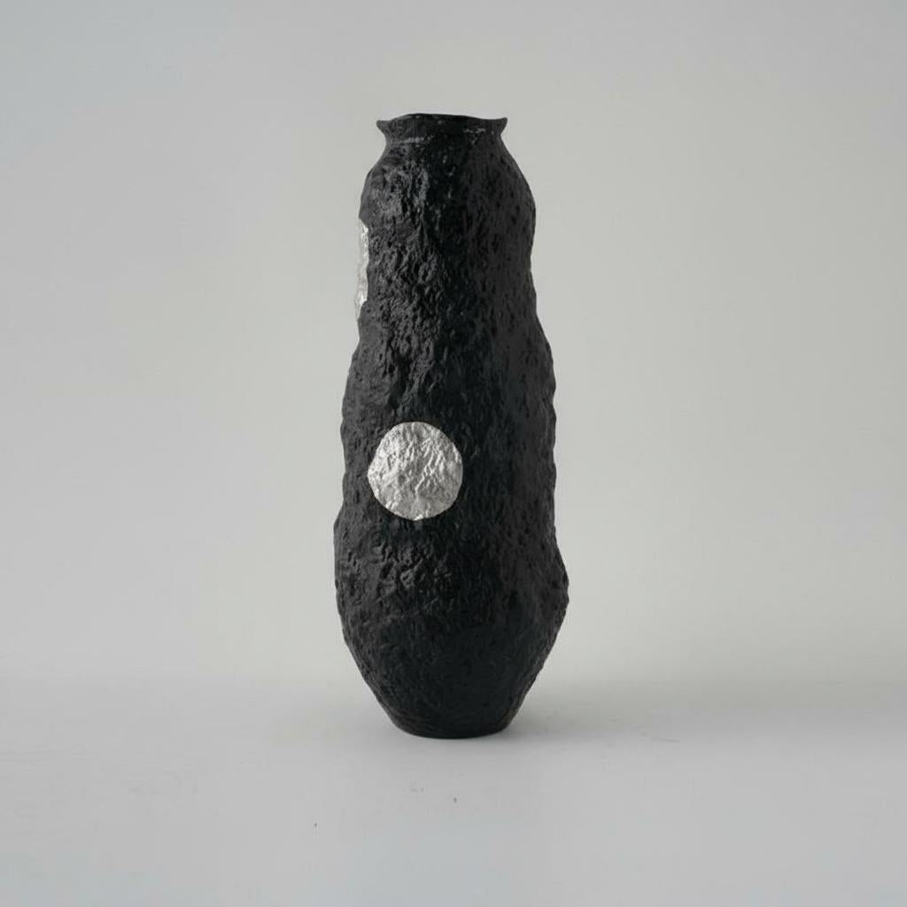 Close up of textured black ceramic surface with silver dot