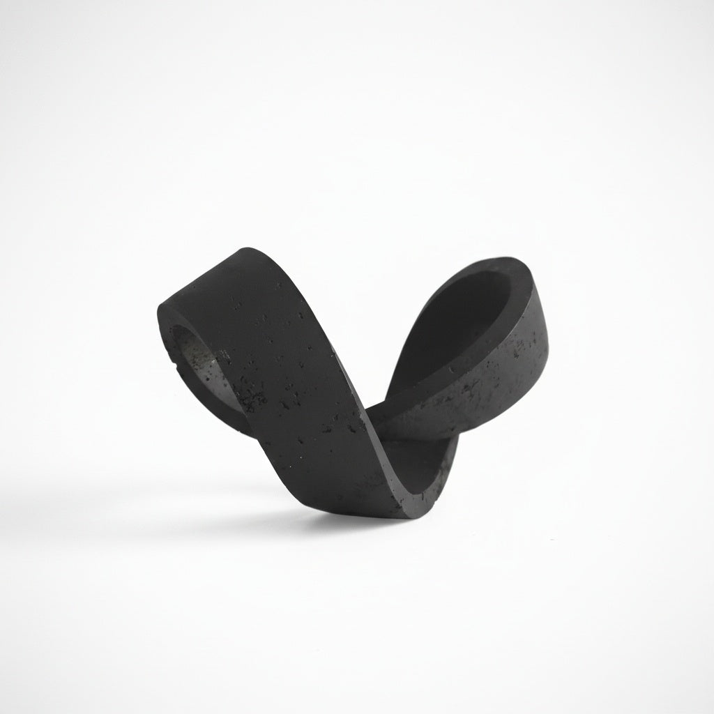 Isolated view of black concrete knot sculpture showing texture