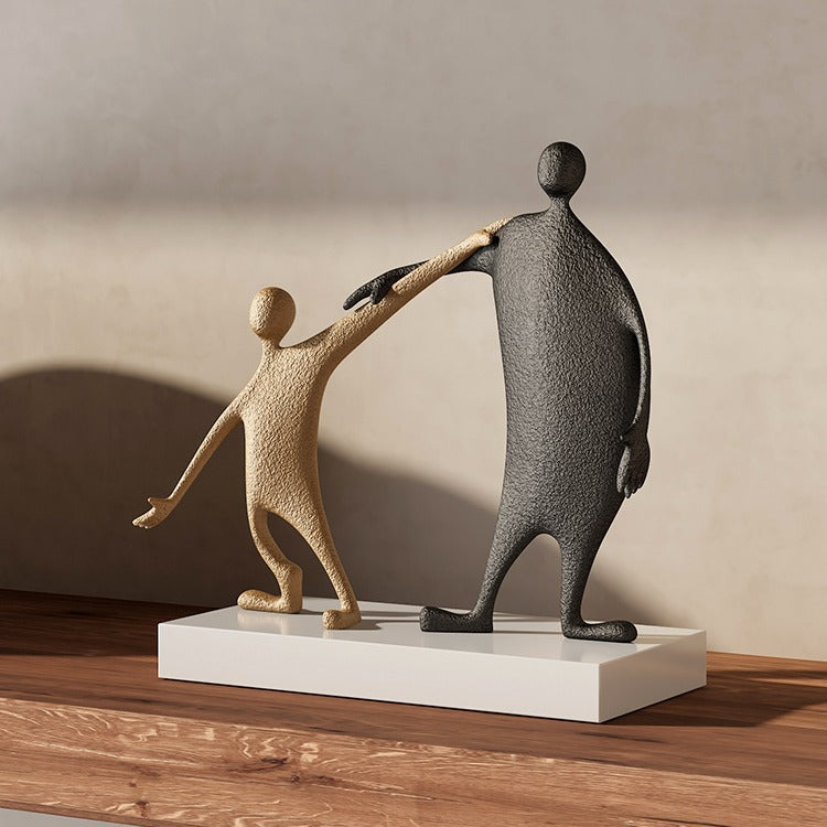 Abstract black and gold metal parent and child sculpture on white base