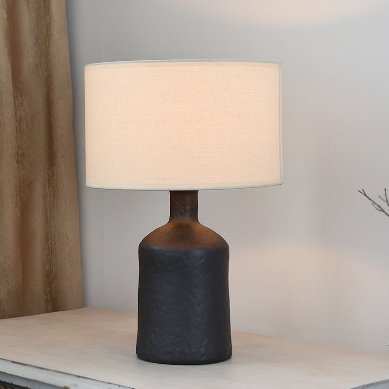 Textured black metal table lamp with drum shade unlit