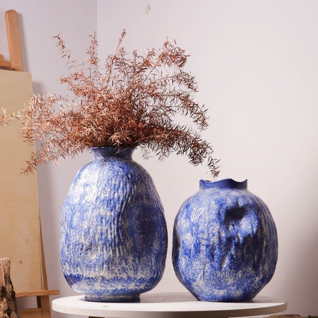 Textured blue ceramic vase with floral arrangement