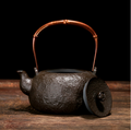Front view of textured cast iron teapot with copper handle