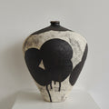 Front view of textured ceramic vase with abstract black pattern