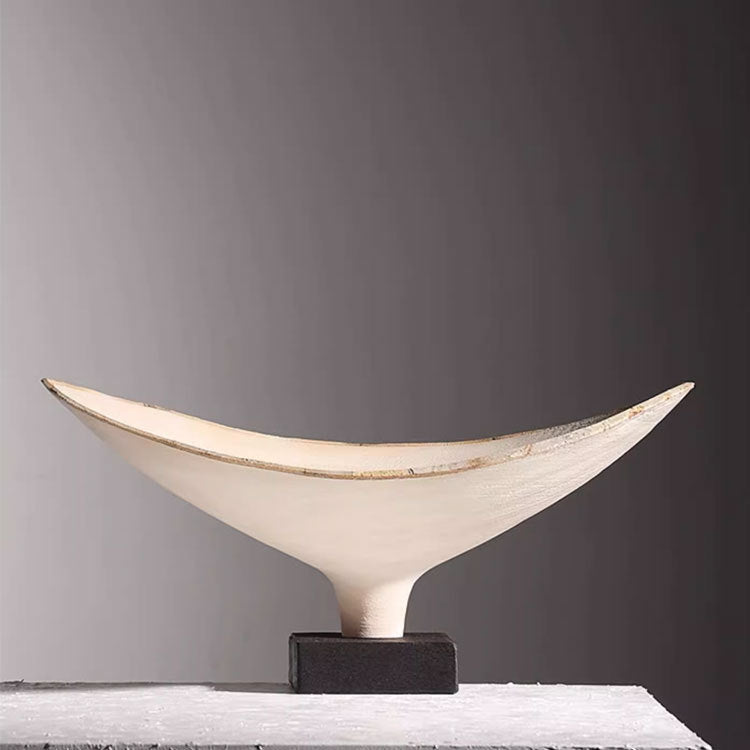 Front view of empty textured ceramic crescent bowl on dark base