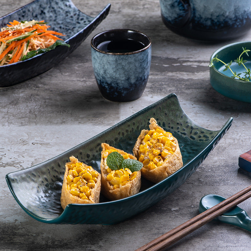 Angled view of textured ceramic serving dish with appetizers on a stone table