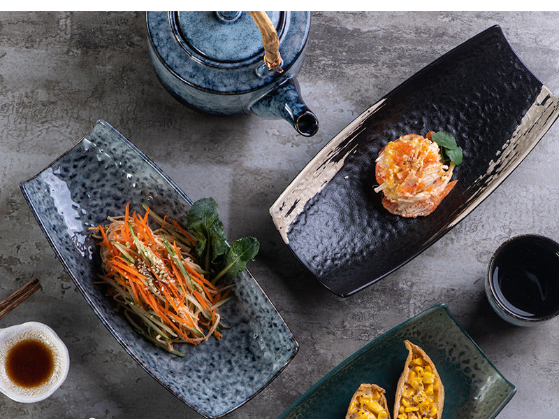 Overhead view of various ceramic serving platters including teal and speckled finishes