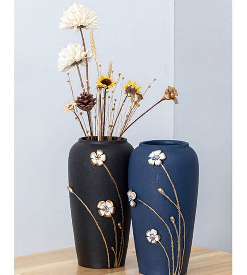 Black and blue embossed floral vases on wooden table