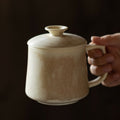 Textured Ceramic Lidded Mug in Sand Beige held in hand