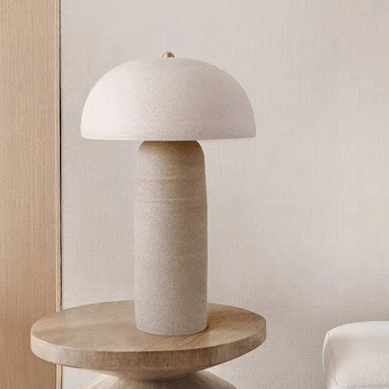 Front view of textured ceramic mushroom table lamp on wooden side table