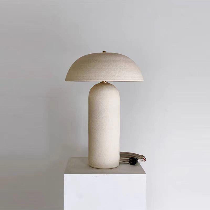 Textured ceramic table lamp illuminated on pedestal