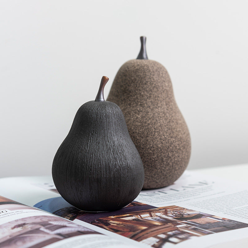 Two textured ceramic pears styled on art books